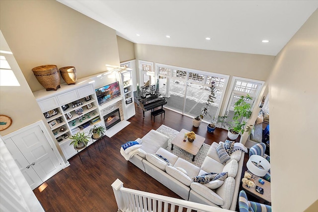 living room with dark hardwood / wood-style flooring and high vaulted ceiling