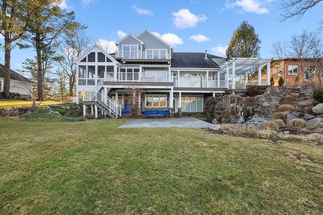 rear view of house with a patio area, a sunroom, a yard, and a wooden deck