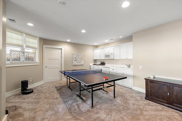 game room featuring light colored carpet and sink