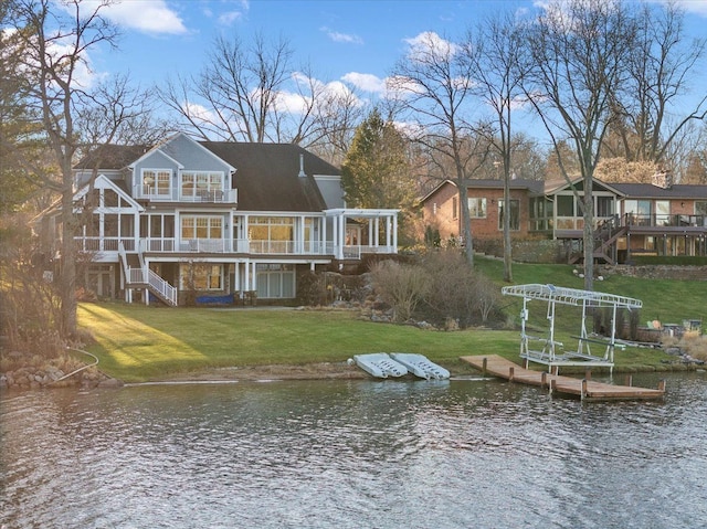 back of property featuring a sunroom, a yard, and a deck with water view