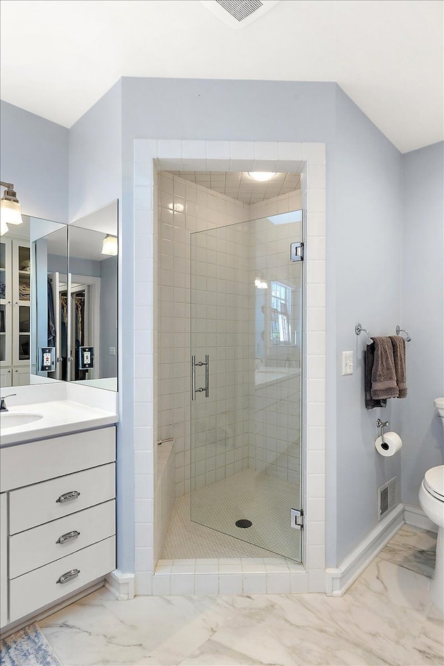 bathroom featuring vanity, toilet, and a shower with shower door