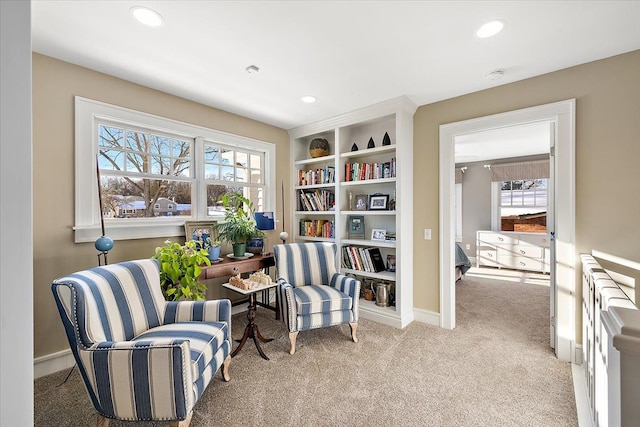 living area featuring radiator heating unit and light carpet