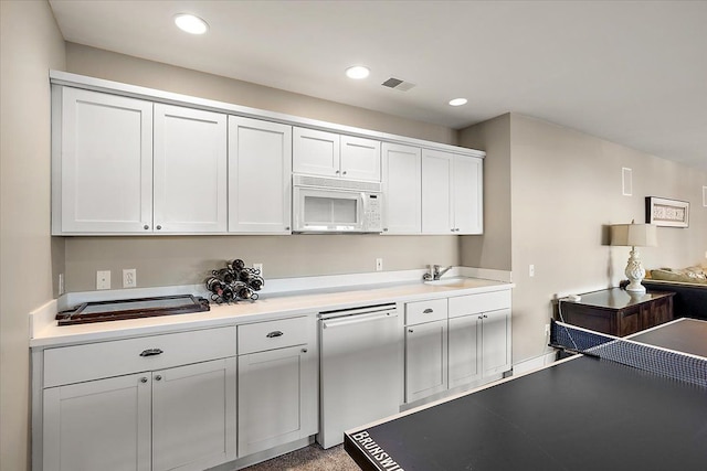 kitchen featuring dishwasher, white cabinetry, and sink