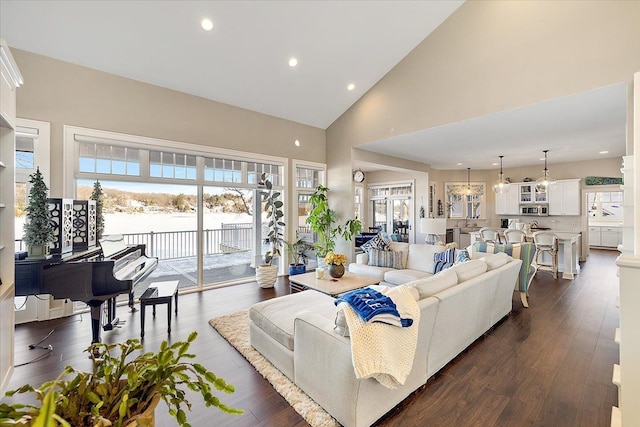 living room with high vaulted ceiling and dark wood-type flooring