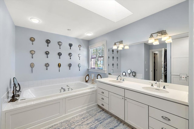 bathroom with a bathing tub, vanity, and a skylight