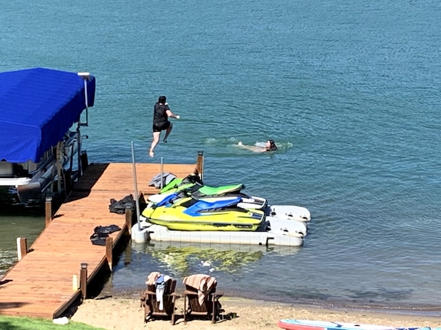 dock area featuring a water view and a view of the beach