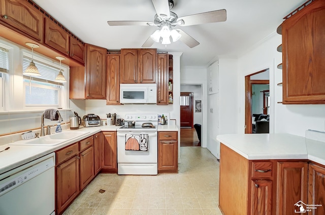 kitchen featuring ceiling fan, sink, hanging light fixtures, white appliances, and ornamental molding