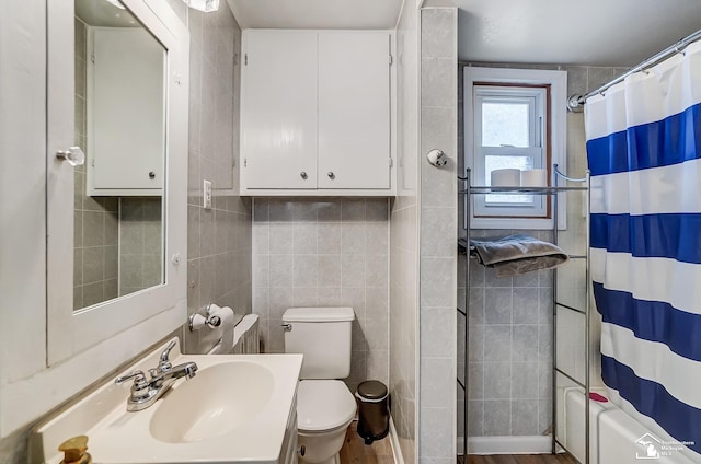 full bathroom featuring shower / bath combo with shower curtain, vanity, tile walls, and toilet