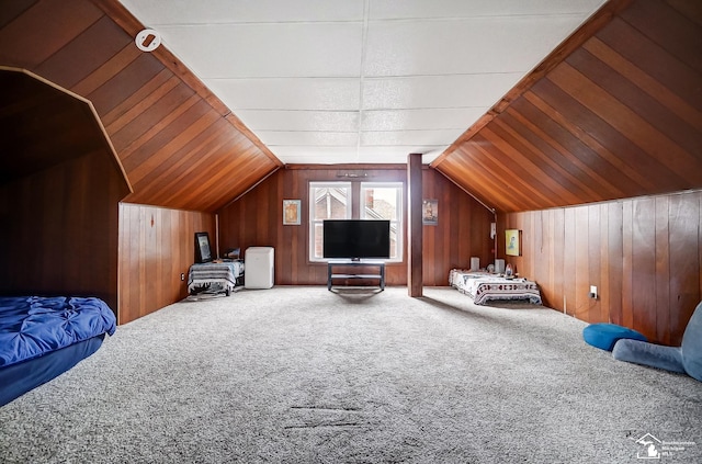 carpeted bedroom featuring vaulted ceiling and wooden walls