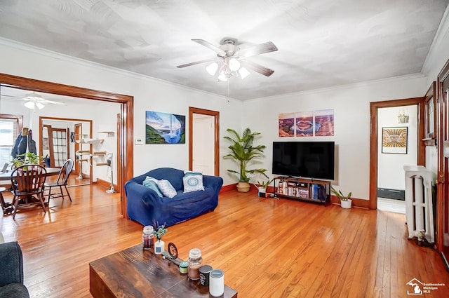 living room with hardwood / wood-style flooring, ceiling fan, and crown molding