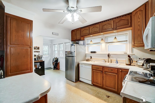 kitchen with plenty of natural light, white appliances, sink, ceiling fan, and decorative light fixtures