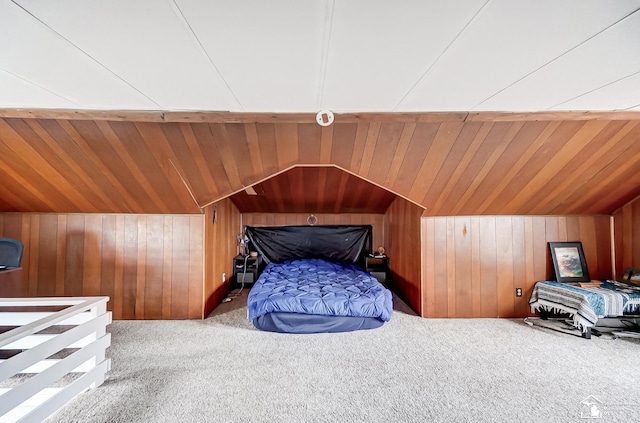 bedroom with wood walls and light colored carpet