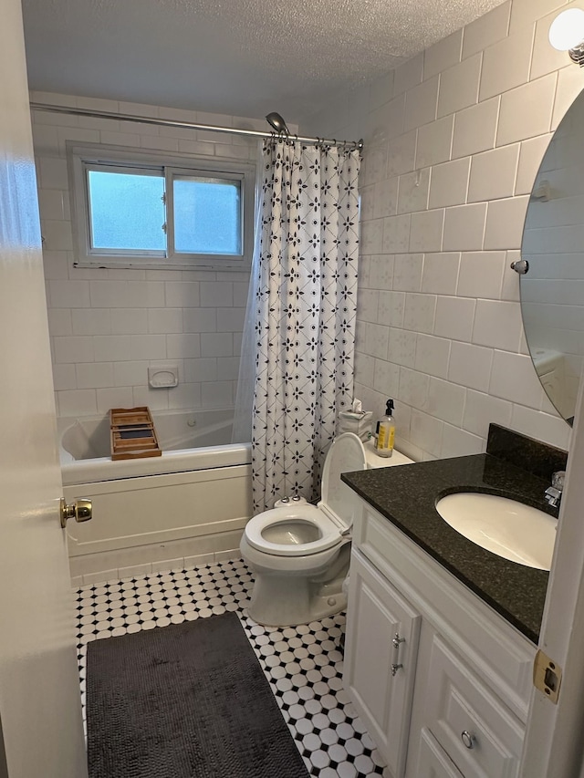 full bathroom featuring tile patterned floors, a textured ceiling, toilet, vanity, and shower / tub combo