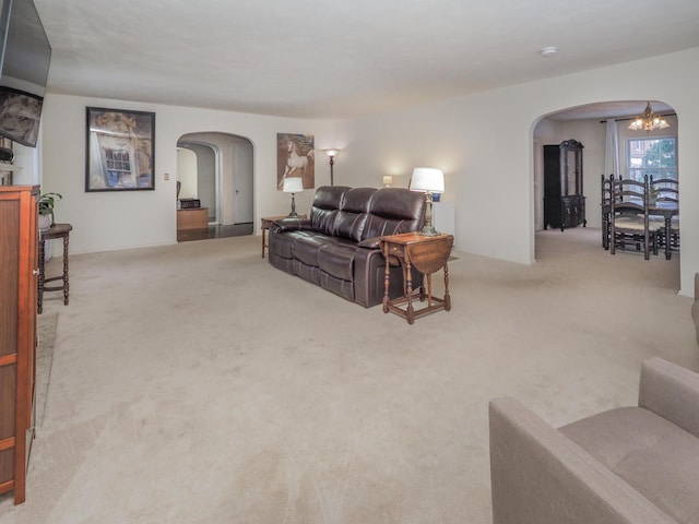 carpeted living room featuring an inviting chandelier