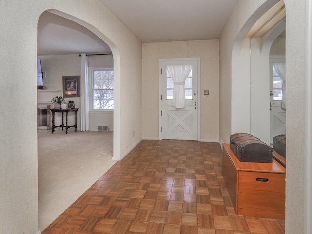 entryway featuring dark parquet flooring