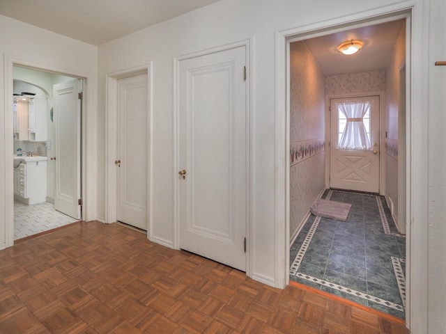 corridor featuring dark parquet flooring and sink