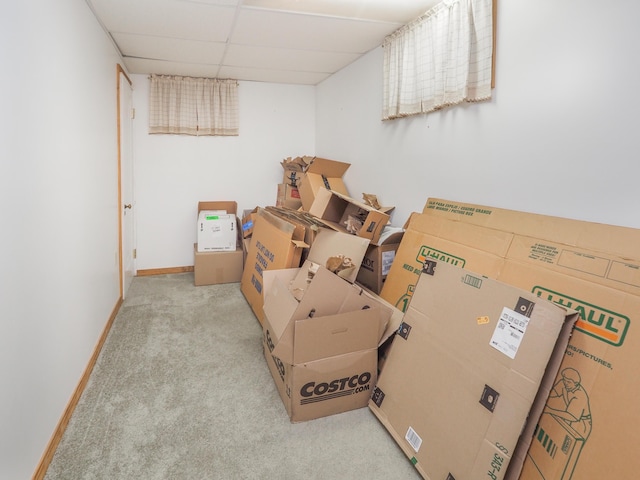 interior space with a drop ceiling and light colored carpet