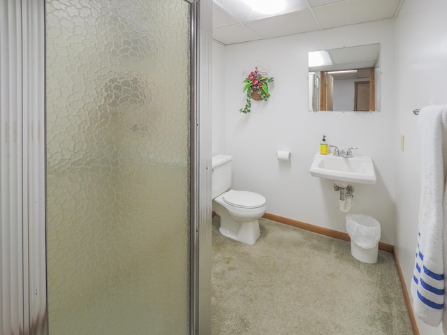 bathroom with a paneled ceiling, toilet, sink, and walk in shower