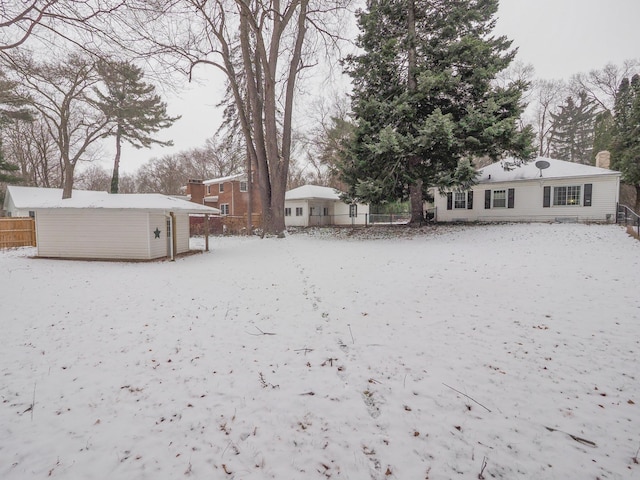 yard layered in snow with an outdoor structure