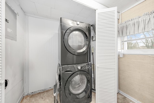 laundry area featuring stacked washer and dryer and electric panel