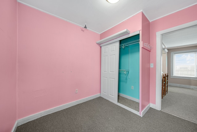 unfurnished bedroom with crown molding, carpet floors, and a closet