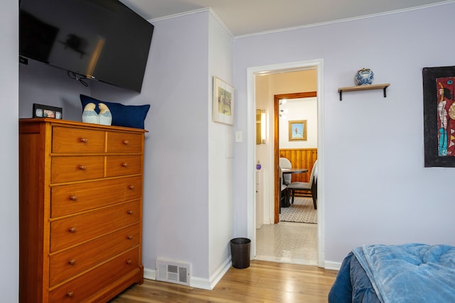 bedroom with light wood-type flooring and crown molding