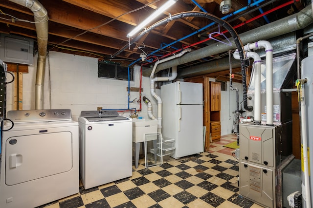 basement with electric panel, heating unit, white fridge, and independent washer and dryer