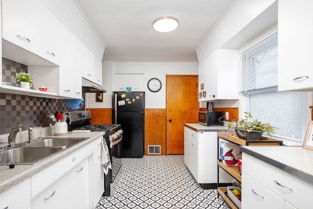 kitchen with white cabinets, black refrigerator, sink, and stainless steel range with gas stovetop