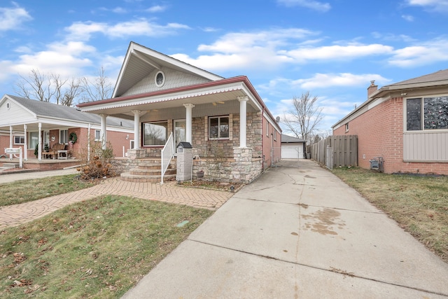 view of front of house with an outbuilding, a porch, a garage, and a front lawn