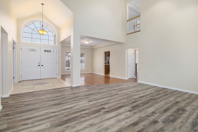 entrance foyer featuring light hardwood / wood-style flooring and a towering ceiling