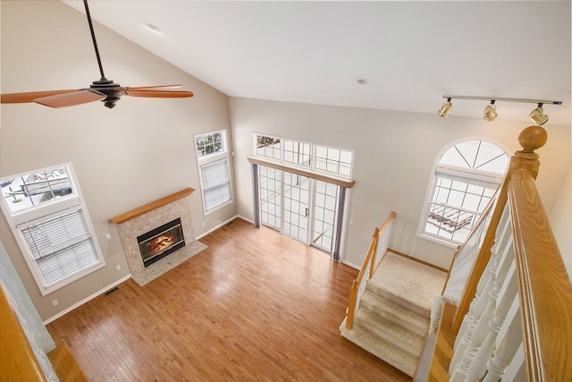 living room with baseboards, visible vents, a tiled fireplace, and wood finished floors