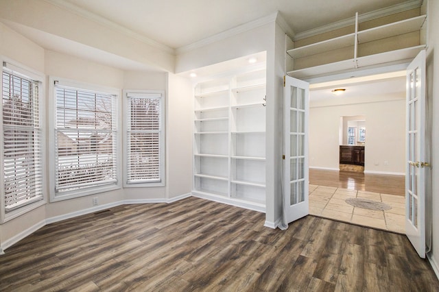 unfurnished room with baseboards, dark wood-style floors, crown molding, french doors, and built in shelves