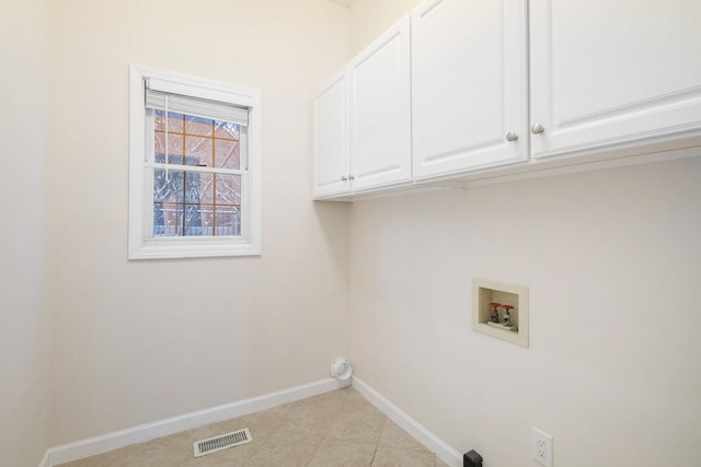 washroom featuring cabinet space, baseboards, visible vents, and washer hookup