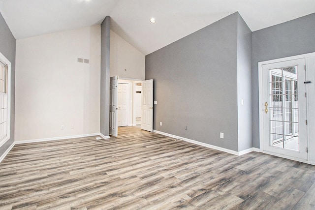 16073 Silverwood Dr, Fenton, MI 48430 - unfurnished room featuring high vaulted ceiling, visible vents, baseboards, and wood finished floors