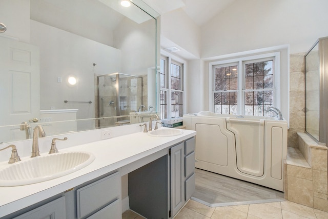 full bath with double vanity, tile patterned floors, a sink, and a shower stall