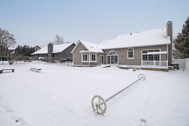 snow covered house featuring central AC