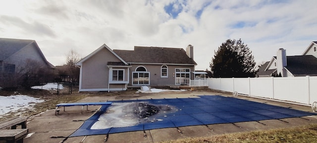 back of house featuring a deck, fence, a fenced in pool, and stucco siding