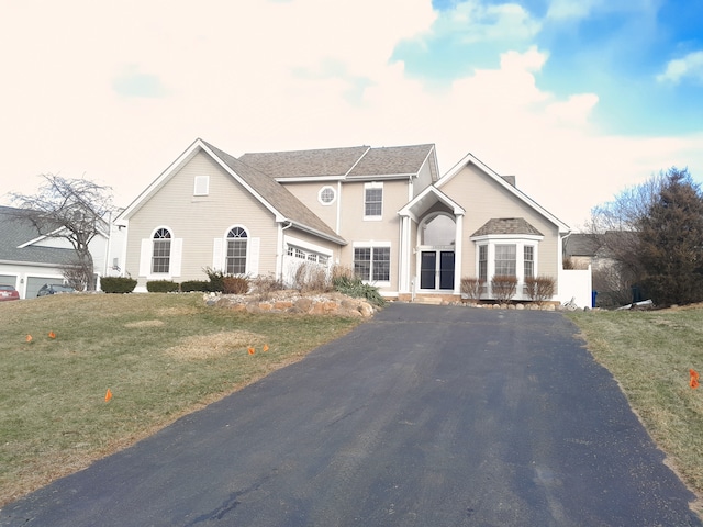 traditional-style house featuring driveway and a front lawn