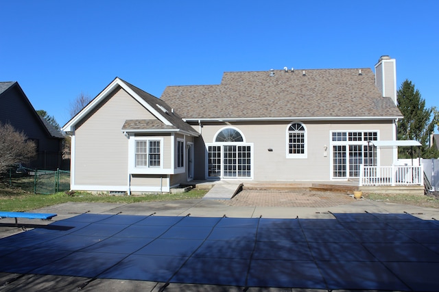 16073 Silverwood Dr, Fenton, MI 48430 - back of property featuring a fenced in pool, a patio, fence, and a chimney