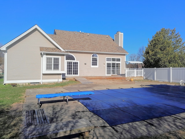 16073 Silverwood Dr, Fenton, MI 48430 - rear view of property featuring fence, a fenced in pool, a patio, and a chimney