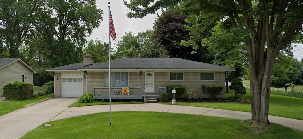 single story home featuring a front lawn, covered porch, and a garage