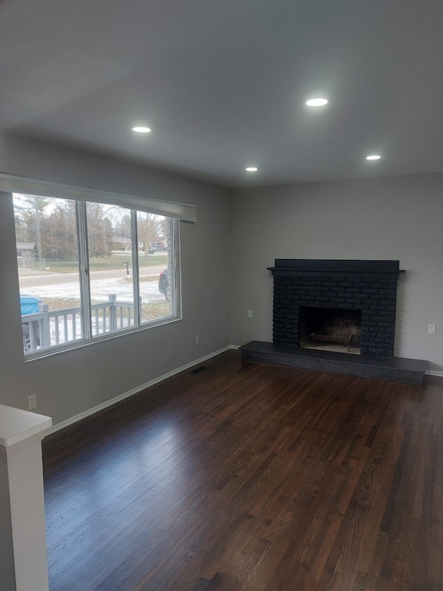 unfurnished living room featuring dark hardwood / wood-style floors and a fireplace