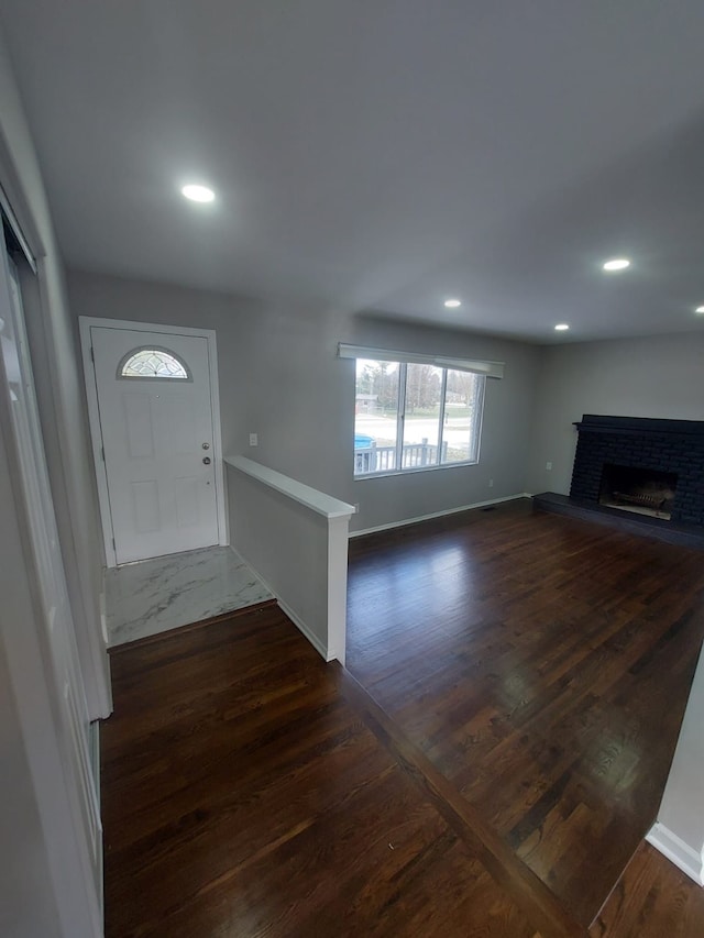 foyer entrance featuring dark hardwood / wood-style flooring and a fireplace