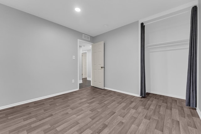 unfurnished bedroom with light hardwood / wood-style floors and a closet