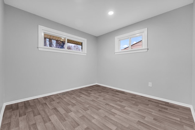 spare room with a wealth of natural light and light wood-type flooring