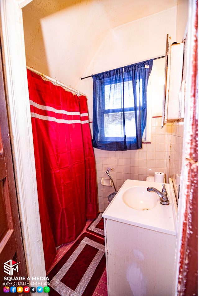 bathroom featuring tile patterned flooring, tile walls, a shower with curtain, and vanity