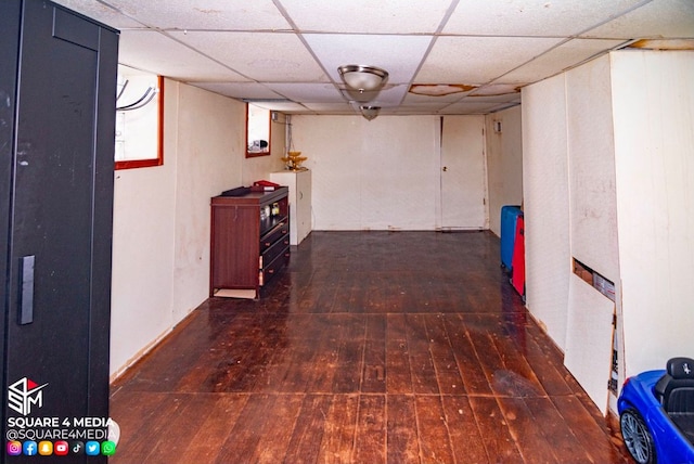 hall featuring a drop ceiling and dark hardwood / wood-style floors