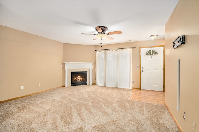 unfurnished living room with ceiling fan and light colored carpet