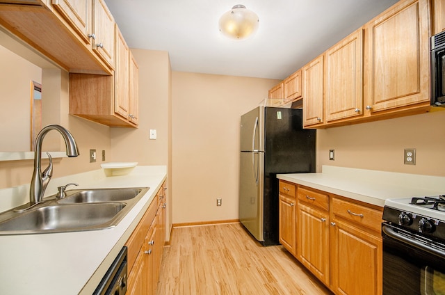 kitchen with light wood-type flooring, black appliances, and sink