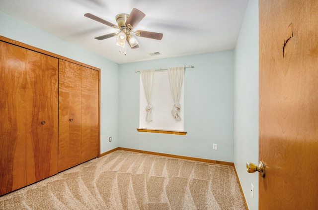 unfurnished bedroom with light carpet, a closet, and ceiling fan